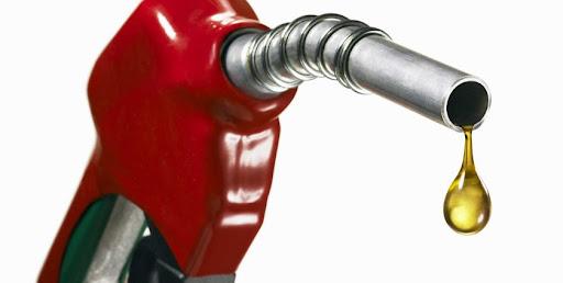 Fuel station worker refills a car at a Kampala petrol station after prices drop.